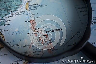 Philippines on a world map through magnifying glass. Stock Photo