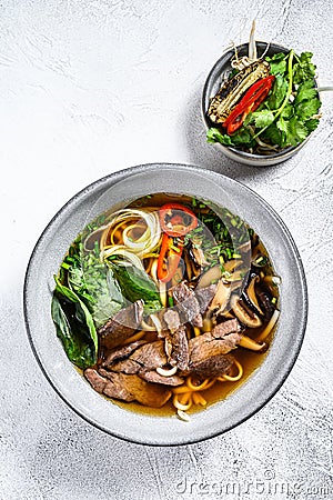 Pho Bo Vietnamese fresh rice noodle soup with beef, herbs and chili. White background. Top view Stock Photo