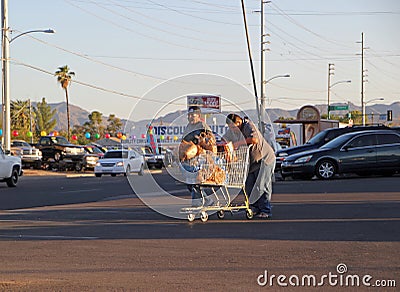 Two men walking with cart full of groceries on supermarket parking lot Editorial Stock Photo