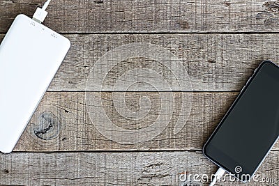 Phone charging with power bank on wood Stock Photo