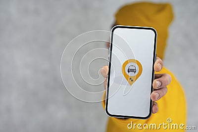 Phone display with Taxi icon on light background. Man holds a mockup smartphone in his hand close-up Stock Photo