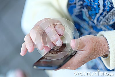 Phone in the hands of an elderly woman Stock Photo