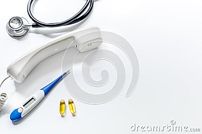 Phone handset, phonendoscope, pills and thermometer on white background top view call doctor space for text Stock Photo