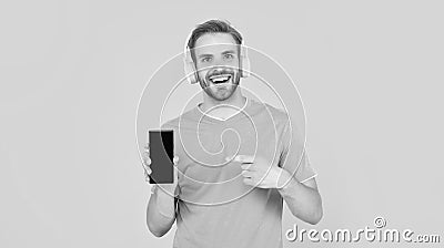 Phone that always keeps you happy. Happy guy pointing at mobile phone. Music smartphone Stock Photo