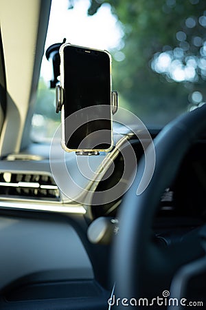 Phone mounted to a windshield of a car in drivers field of view Stock Photo