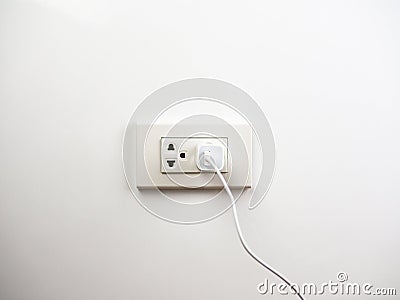 Phone plugged in on socket wall, charging Stock Photo