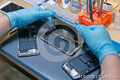 Phone repair concept a mobile phone being assembled by the repairman on the desk with the various specific equipment Stock Photo