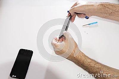 Phone repair in a service center. Dismantling glass from a mobile phone. Replacing the touchpad matrix of the glass touchpad Stock Photo