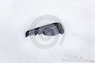 Testing a rugged mobile phone in snow Stock Photo