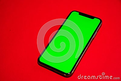 Phone XS, Phone smartphone, green screen on Red background Stock Photo