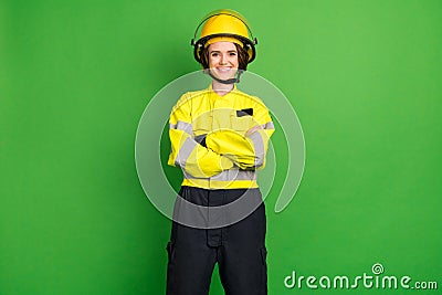 Photo of adorable cute young firewoman dressed yellow uniform helmet arms crossed smiling isolated green color Stock Photo