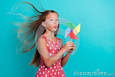 Photo of adorable funny little lady dressed dotted sarafan blowing windmill toy isolated teal color background Stock Photo