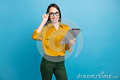 Photo of adorable intelligent lady wear yellow shirt spectacles working modern gadget isolated blue color background Stock Photo