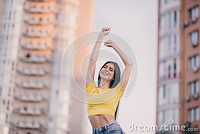 Photo of adorable satisfied person closed eyes raise hands beaming smile enjoy free time walk outside Stock Photo