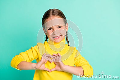 Photo of adorable sweet little girl make hands heart figure wear yellow turtleneck isolated on shine teal color Stock Photo