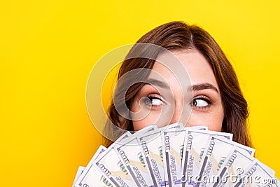 Photo of adorable sweet shiny lady dollars fan close half face looking empty space isolated yellow color background Stock Photo