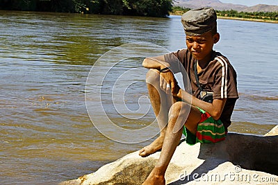 Photo of adorable young happy boy - african poor child on the ri Stock Photo