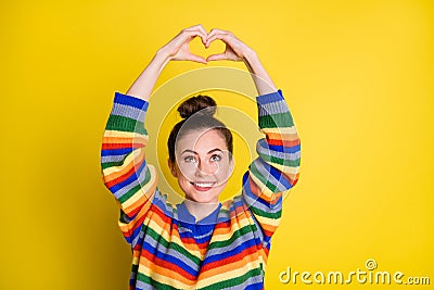 Photo of adorable young lady make hands look heart shape above head isolated on shine yellow color background Stock Photo