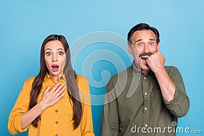 Photo of afraid shocked scared mature man and woman horrified bad mood isolated on blue color background Stock Photo