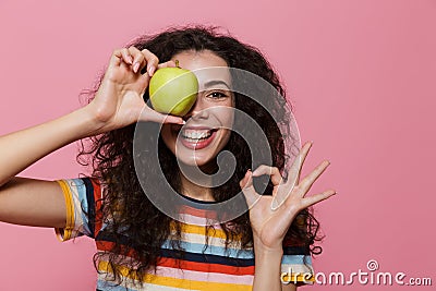 Photo of amusing woman 20s with curly hair smiling and holding g Stock Photo