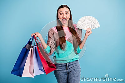 Photo of astonished screaming wow omg funny girl holding several bags in hands showing pile of american banknotes Stock Photo