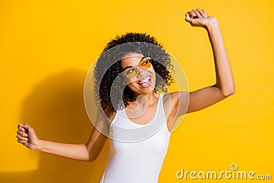 Photo of attractive afro american lady dreamy dancer raise fists wear sunglass isolated on bright yellow color Stock Photo