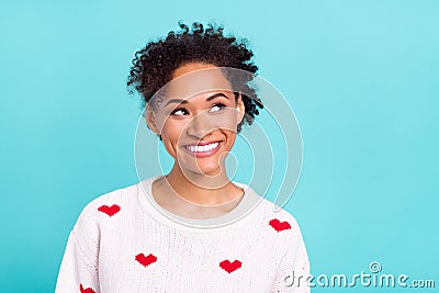 Photo of attractive dreamy afro girl wear heart print pullover smiling looking empty space isolated blue color Stock Photo