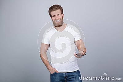 Photo of attractive ginger man with satisfied expression, has thick beard, rejoices promotion at work, dressed in casual t shirt, Stock Photo