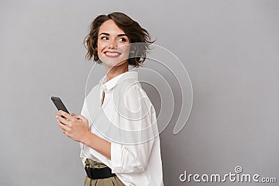 Photo of attractive woman 20s smiling and holding mobile phone Stock Photo