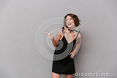 Photo of attractive woman 20s wearing black dress smiling at cam Stock Photo