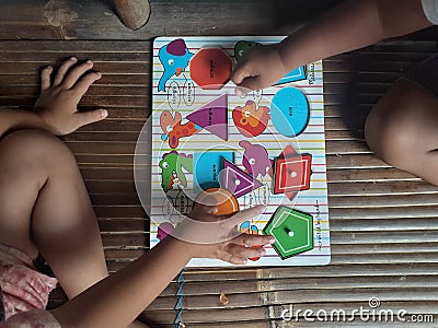 Photo baby son playing puzzles. Stock Photo
