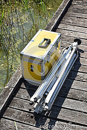 Photo bag and metal photo tripod on the wooden pier Stock Photo