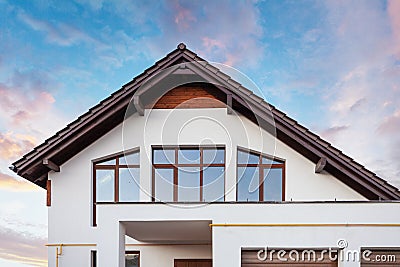 Photo of beautiful comfort and new house with brown roof large windows and white wall against calm blue sky Stock Photo