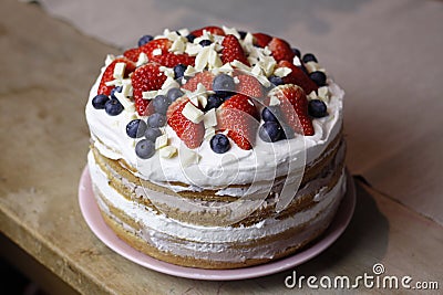 naked cake with a white cream strawberries blueberries and a white chocolate Stock Photo
