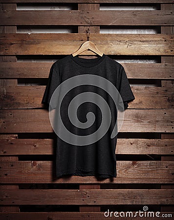 Photo of black tshirt holding on wood background Stock Photo