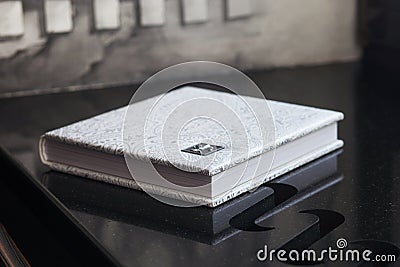 Photo book with a cover of genuine leather. White color with decorative stamping. Wedding or family photo album. Family value Stock Photo