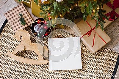 Photo book in white leather cover, wedding or family photo album under the Christmas tree surrounded Stock Photo