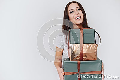 Photo of a brunette girl with evening make-up holding a stack of many gift boxes in her hands Stock Photo