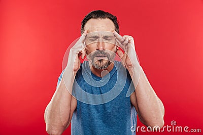 Photo of caucasian man with stubble rubbing temples closing eyes Stock Photo