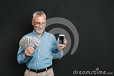 Photo of caucasian retired man 60s with gray hair holding mobile Stock Photo
