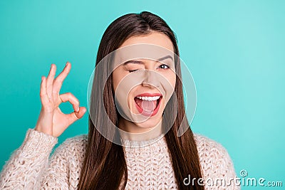 Photo of charming cute nice funny girlfriend showing you ok sign wearing pullover blinking while isolated with teal Stock Photo