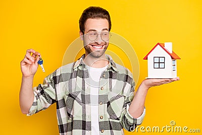 Photo of charming happy young man hold hand keys house real estate isolated on yellow color background Stock Photo