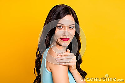 Photo of charming tender girl embrace shoulder look camera wear blue top isolated yellow color background Stock Photo