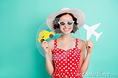 Photo of charming toothily smiling beautiful girl holding taxi and plane in her hands willing to collide them while Stock Photo