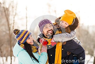 Photo of cheerful family mommy daddy daughter piggyback happy positive smile look each other winter trip outdoors Stock Photo