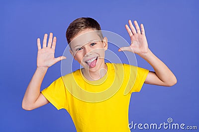 Photo of cheerful foolish preteen boy teasing fooling grimacing on purple color background Stock Photo
