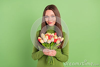 Photo of cheerful happy young nice lady hold hands bunch tulips spring on green color background Stock Photo