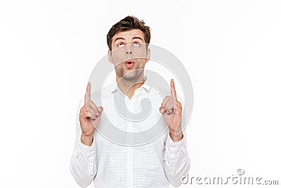 Photo of cheerful man 30s smiling and pointing fingers upward at Stock Photo