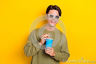 Photo of cheerful man wear khaki trendy clothes hold delicious drink watching comedy film isolated on yellow color Stock Photo