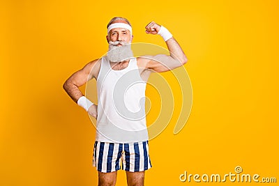 Photo of cheerful positive attractive handsome old man demonstrating his muscles looking intently at you holding hand on Stock Photo